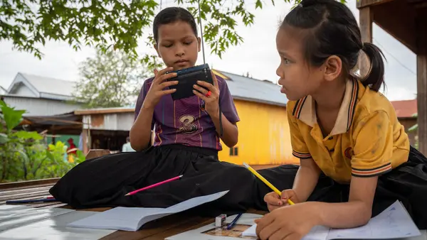 When their school was closed to prevent the spread of COVID-19, Kvas Em and Rocham Yhang kept up with their lessons via a radio provided by UNICEF in Paor Kekchong village, Borkeo District, Rattanakiri, Cambodia.