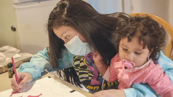 Jennifer, 15, coloring with daughter Scarlett, migrated from Guatemala to the United States when she was 13. She made the trip with her sisters, eventually reunited with their mother in Hempstead, N.Y.