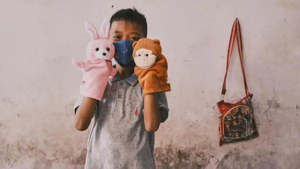 Dwi Rizky Saputra plays with toys from a recreational kit he received for children affected by COVID-19 at his home in Jombang, Indonesia, on 22 October 2020.