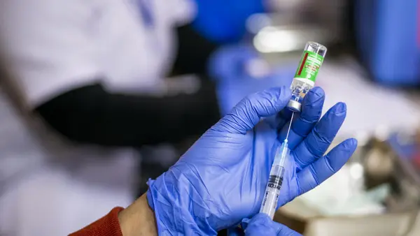 In January 2021, a nurse prepares to administer a COVID-19 vaccine at Sitaram Bhartiya Institute of Science & Research in New Delhi, India. 