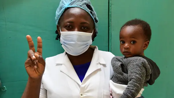 A nurse at Buéa Regional Hospital in Buéa, southwest Cameroon, flashes a "V for vaccinated" sign showing that she has received a coronavirus vaccine.
