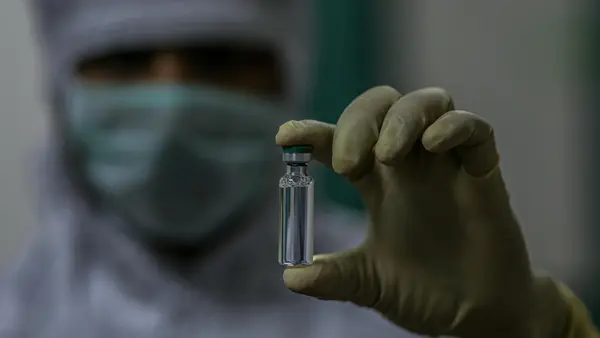 On 24 February 2021, an employee holds a COVID-19 vaccine vial produced for the COVAX facility at a manufacturer in Pune, a city located in the western Indian state of Maharashtra.