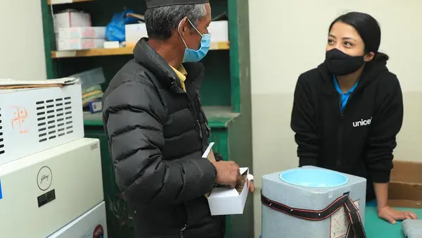 Mitthi Jirel (left), staff at the district hospital in Jiri in Dolakha District in northeastern Nepal, with UNICEF staff Preena Shrestha (right) in the hospital's vaccine storage room on February 26, 2021.