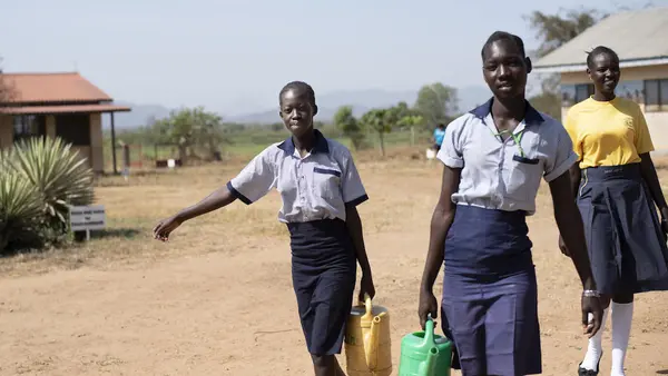 From left: 17-year-olds Margaret and Elizabeth, and Nite, 19, carry water from the newly rehabilitated borehole at Ilumum Primary School in Torit, South Sudan. 
