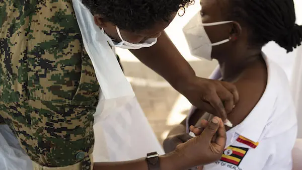 Baluka Winfred Viola, a Nursing Officer at Kisenyi Health Center IV, receives a shot of the AstraZeneca COVID-19 vaccine at Mulago National Referral Hospital during the official launch of  COVID-19 vaccination in Uganda.