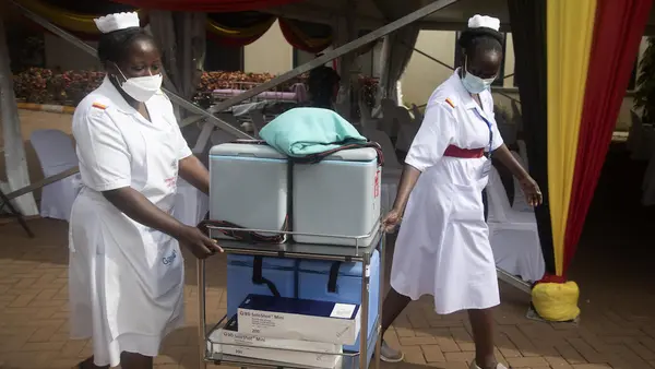 Health workers move vaccine cooler boxes to vaccination points at the official launch of COVID-19 vaccination efforts in Uganda at Mulago National Referral Hospital on March 10, 2021. 