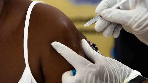 A health worker receives her COVID-19 vaccination. 