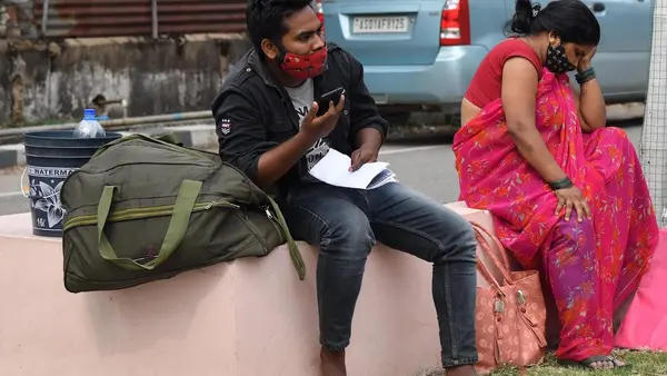COVID-19 patients sit outside the Gauhati Medical College COVID Care Hospital in Kalapahar, Guwahati, India, where all beds are full on April 30, 2021.