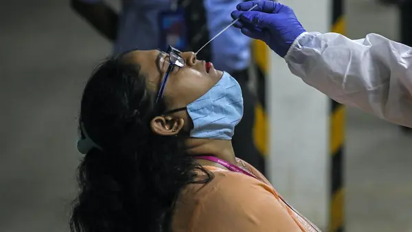 A health worker takes a nasal swab sample to test for COVID-19 at a facility in the Malad area of Mumbai, India, on April 30, 2021.
