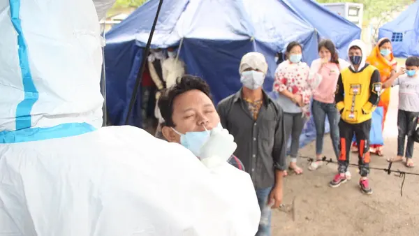 On May 5, 2021, individuals and families make the crossing from India into Nepal at the Birgunj point of entry in Parsa District in southern Nepal, where they are met by border personnel and health workers for temperature checks and antigen tests.