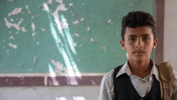 Twelve-year-old Ahmed standing in his classroom in Al-Hamzi school, which was damaged by the conflict in 2015, in Yemen's Hajjah governorate, March 2021.