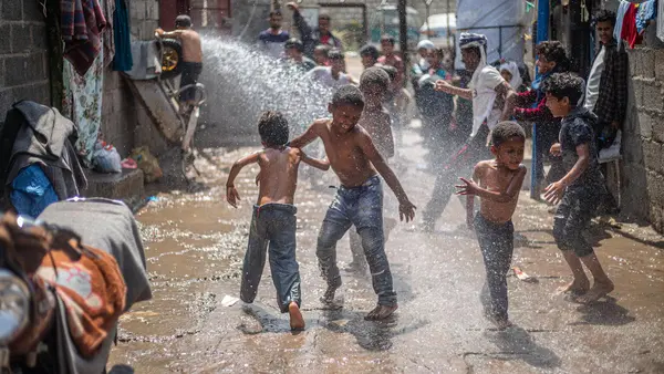 At a displacement camp in Al-Dhihar district, Ibb, Yemen, children celebrate the successful rehabilitation of the nearby water pump and the return of safe water.