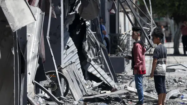 On May 17, 2021, Palestinian children walk in front of a house that was targeted by the Israeli bombardment in Gaza City.