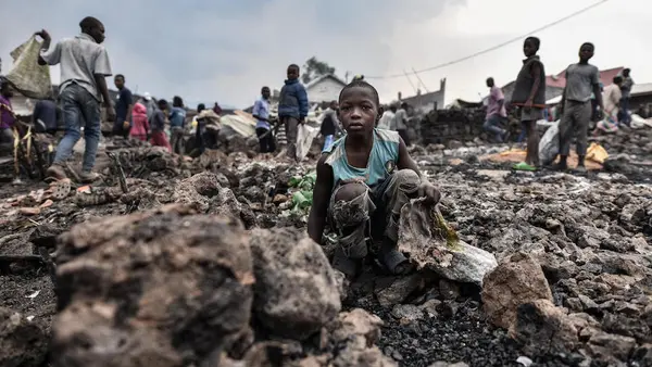 Children stand amidst lava from the volcanic eruption of Mount Nyiragongo, which occurred late on May 22, 2021 in eastern Democratic Republic of the Congo.