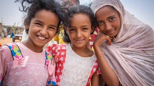 Three Malian girls pose outside the food distribution center at the UNICEF-supported Mbera refugee camp in Mauritania.