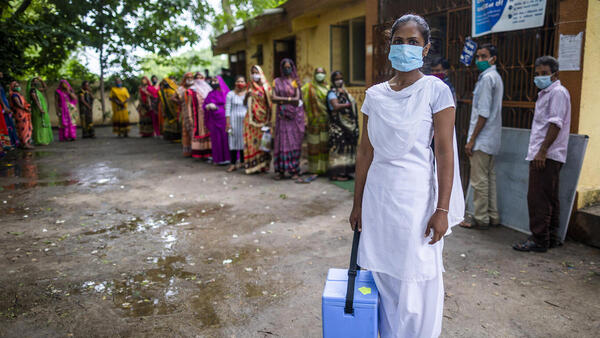 Nilam Bamaniya, a 23-year-old general nursing midwife, holds a vaccine carrier filled with vaccine doses for a COVID-19 vaccination session at a UNICEF-supported public health center in Samlaya, Vadodra, Gujarat, India on July 20. 2021. 
