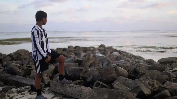 Ahmed Anjal bin Anis, 9, at a beach in Dhiffushi, Maldives. His school suffers from regular sea water flooding due to sea level rise. “But even if the school gets flooded, I still want to go,” he says. Dhiffushi, Maldives, October 2021