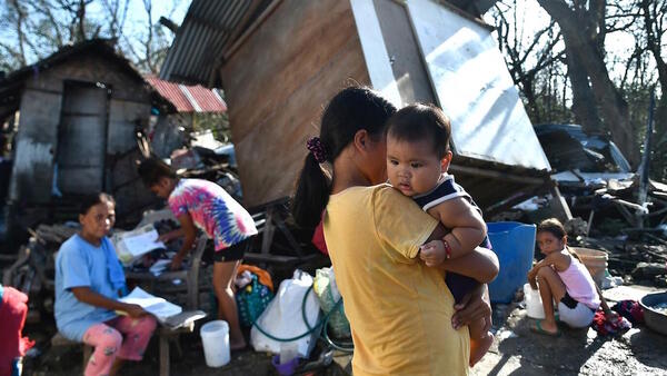 Residents gather next to their destroyed house in Carcar, Philippines' Cebu province on December 18, 2021, days after Super Typhoon Rai hit the city.