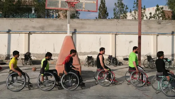 On 22 November 2019, adolescent boys use wheelchairs in an outdoor basketball court at Abdul Ahad Karzai Orphanage in Kandahar, Afghanistan. Many of them have been injured in conflict and have lost limbs in landmine accidents.