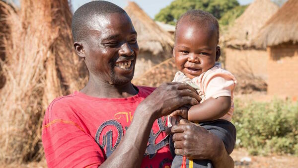 One-year-old baby Moses and father Ponsilio Phiri playing in Zambia in 2020. Baby Moses is enrolled in the LEGO Playful Parenting program implemented by UNICEF.