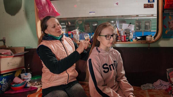Liudmyla Voloshenko, 41, combs her 10-year-old daughter Sonia’s hair in one of the trains that have become home for thousands of civilians in the Kharkiv, Ukraine metro. 