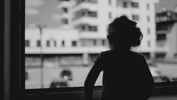 Three-year-old Lana looks out the window of her family's home in Bosnia and Herzegovina. 