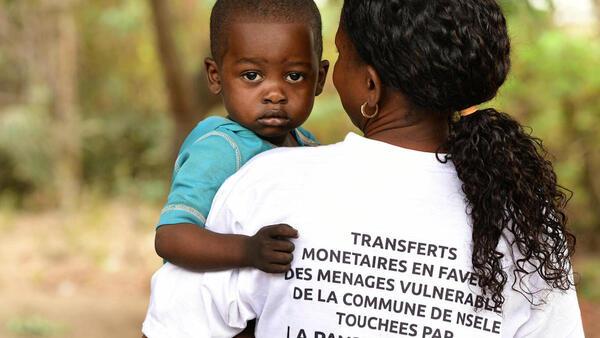 In October 2020, an agent holds a boy while registering vulnerable families in Moro, a suburb of Kinshasa, Democratic Republic of Congo. 