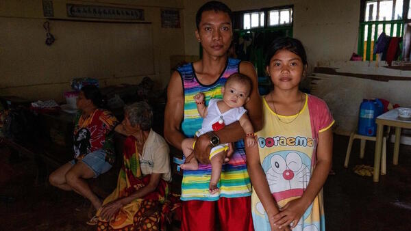 Nicole Angela Cariño, 17, her husband, Mike De Jesus, and their 3-month-old baby, Alia, set up housekeeping in a school classroom with several other families after Typhoon Rai hit Dinagat Island, the Philippines on December 16, 2021.