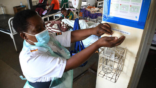 The in-charge nurse at Fort Portal Regional Referral Hospital in Uganda sanitizes her hands after attending to patients in the pediatric ward. 