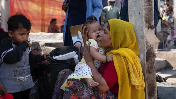 Rohingya refugee Tahrim consoles her infant daughter after their shelter was destroyed in a fire on January 9, 2022 in Cox's Bazar, Bangladesh.