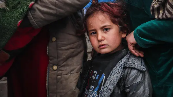 Internally displaced children and families line up for UNICEF emergency assistance in Hasakeh city, northeast Syria, on January 27, 2022.