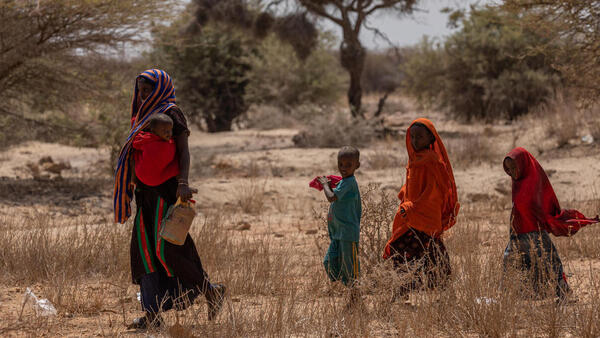 A woman and her children cross a dry field near Saglo village, Somali region, Ethiopia on January 20, 2022.