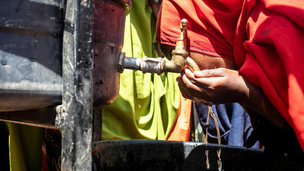 A student takes a drink as she washes her hands at the UNICEF-supported Qansaxleey Primary and Secondary school playground in Dolow, Somalia.