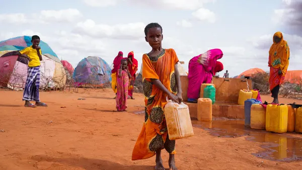 Ten-year-old Hibo carries water in a jerrycan to her temporary home at the UNICEF-supported Kaharey IDP camp in Dollow, Somalia.