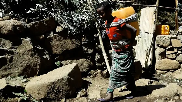 Zufan, 10, of Ethiopia, carrying a heavy jug of water back from the community tap, a daily chore that keeps her out of school.
