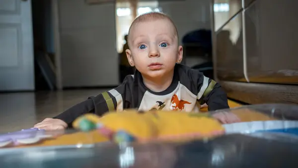 Six-month-old Yehor of Ukraine looks up while crawling.
