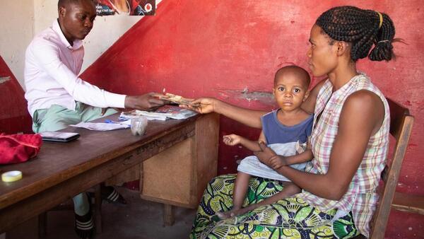 Pauline of Manono, Tangayika province, DRC, receives cash support from UNICEF.
