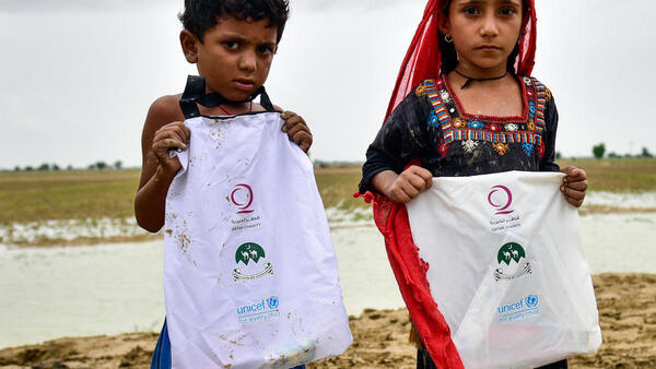 Children in Naseerabad district, Balochistan province, Pakistan, hold UNICEF hygiene kits distributed after flash floods caused by heavy monsoon rains devastated remote rural communities. 
