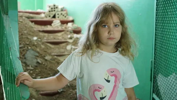 Eight-year-old Nastya stands amidst rubble in her damaged school in Buzova, Ukraine.