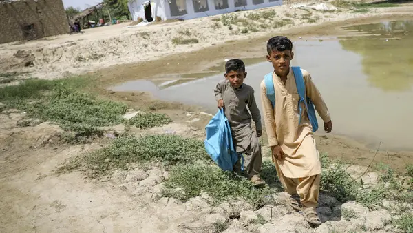 Brothers return home after attending school at a UNICEF-supported Temporary Learning Center in flood-damaged Balochistan Province, Pakistan.