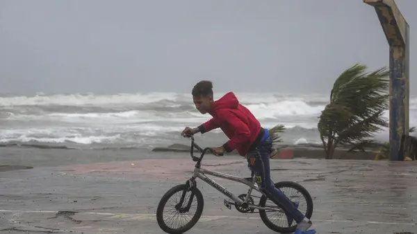 A youth rides his bike in Nagua, Dominican Republic, on Sept. 19, 2022, as Hurricane Fiona passes through the country. 