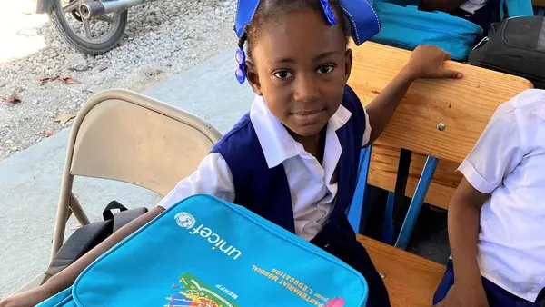 A young student in Haiti with UNICEF-provided school supplies distributed after the 2021 earthquake to ensure kids could keep learning.