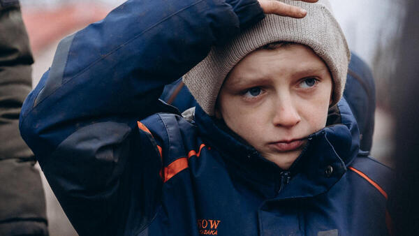 Thirteen-year-old teenager waits in line at a checkpoint in Lyman, Ukraine to recieve lifesaving supplies