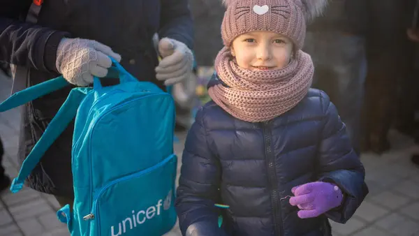 On Dec. 20, 2022, a Ukrainian child receives a UNICEF backpack at the Sloviansk rail station in the Kramatorsk district of Ukraine's Donetsk Oblast. 