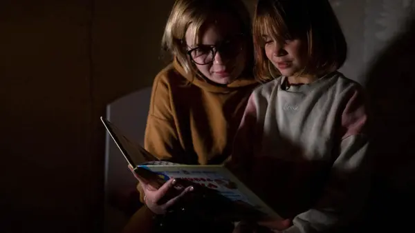 In Bucha, Ukraine, 7-year-old Varvara reads her favorite fairy tale, the story of a fox who is afraid of the spring, by candlelight. 
