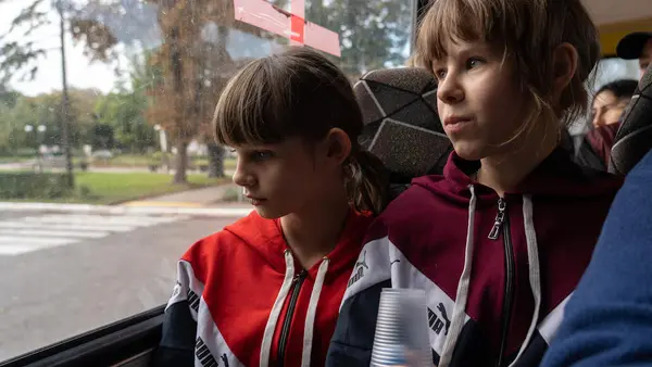 Sisters Anya, 10, left, and Polina, 11, evacuate their home in eastern Ukraine with their mother and siblings.