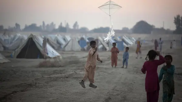 A boy flies a kite at a camp for families displaced by flooding in Sindh Province, Pakistan.