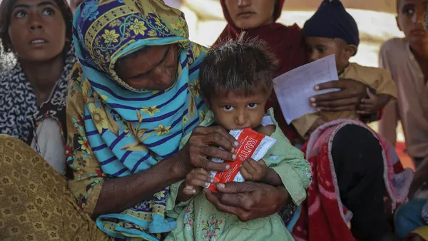 A child suffering from severe acute malnutrition is given Ready-to-Use Therapeutic Food at a UNICEF-supported camp in Sindh province, Pakistan, where families displaced by catastrophic flooding are receiving emergency assistance..