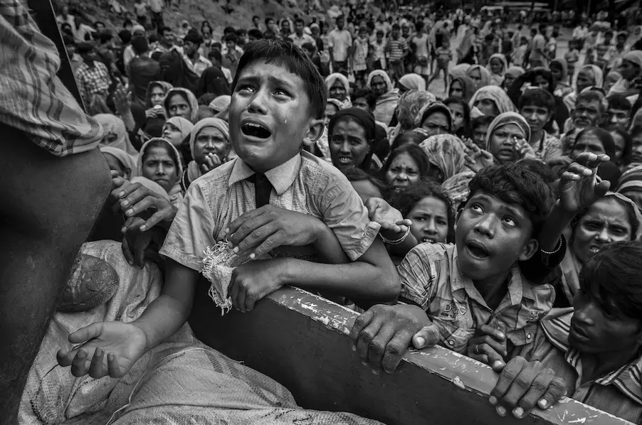 A young Rohingya refugee cries as he climbs on a truck distributing aid near the Balukhali refugee camp, Cox's Bazar, Bangladesh on September 20, 2017. A young Rohingya refugee cries as he climbs on a truck distributing aid near the Balukhali refugee camp, Cox's Bazar, Bangladesh on September 20, 2017.