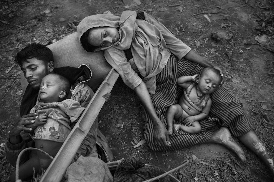 On October 2, 2017, Minara Hassan and her husband, Ekramul, lie exhausted on the ground with their children on the Bangladesh side of the Naf River, after fleeing their home in Maungdaw, Myanmar.
